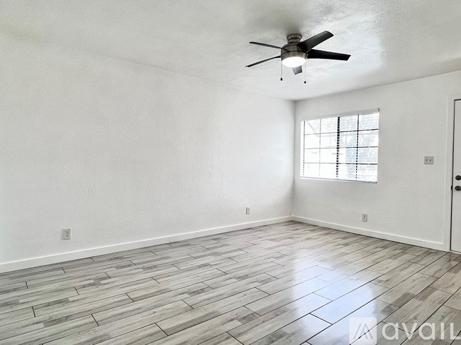 A room with a ceiling fan and a window.