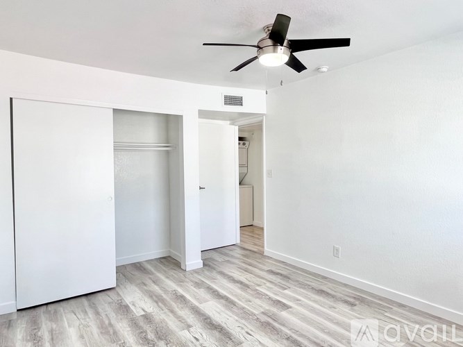 A room with a ceiling fan and a white door.