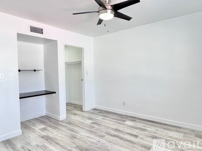 A room with a ceiling fan and a bench against the wall.