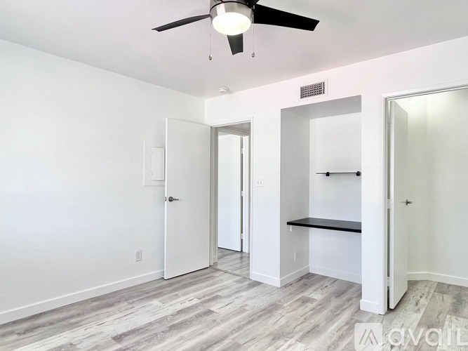 A room with a ceiling fan and a bench.