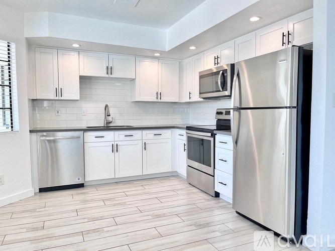 A modern kitchen with stainless steel appliances and white cabinets.