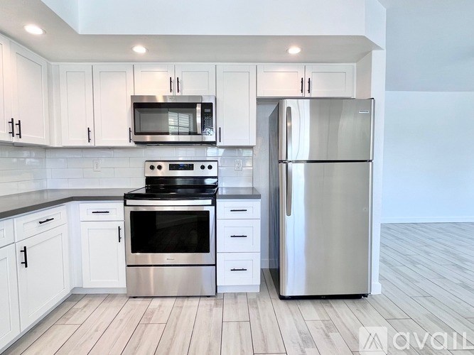 A kitchen with white cabinets and stainless steel appliances.