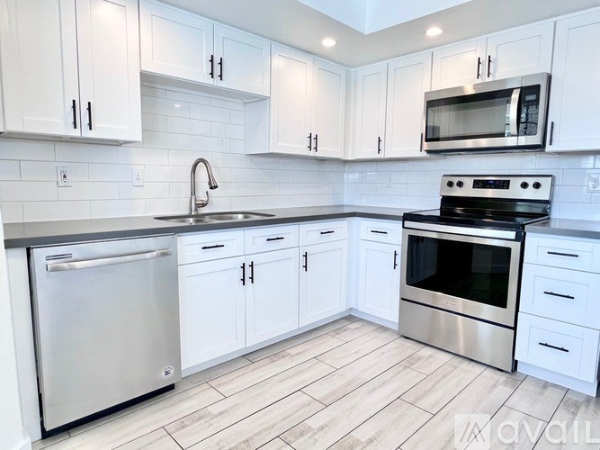 A kitchen with white cabinets and stainless steel appliances.