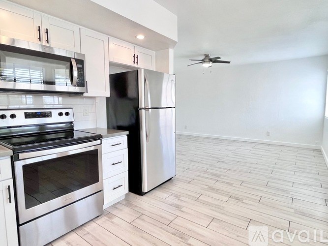A kitchen with a stove top oven and a refrigerator.