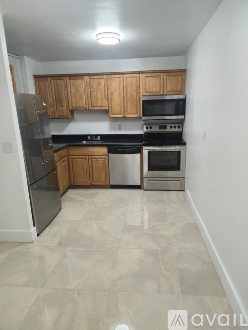 A kitchen with wooden cabinets and black appliances.