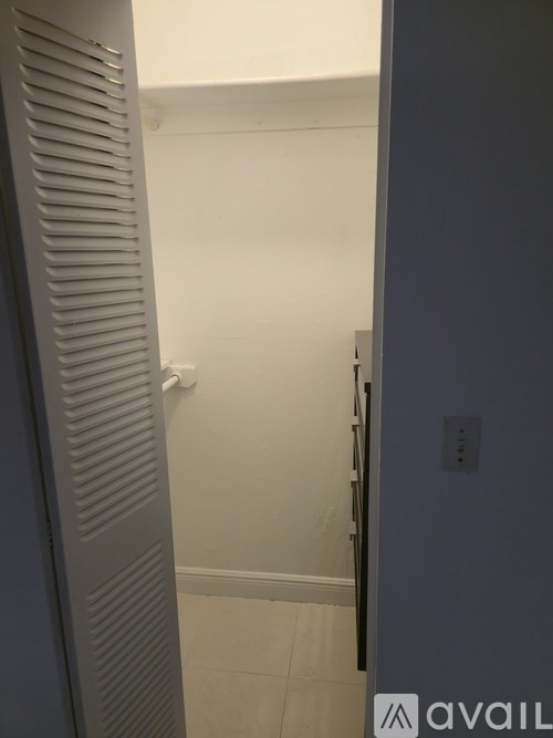 A white door with a grey frame is open.