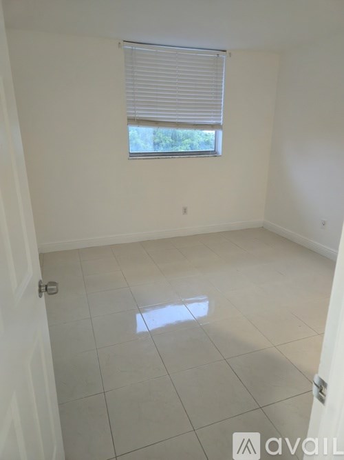 A room with a window and a tiled floor.