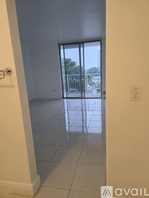 A room with a sliding glass door leading to a balcony.