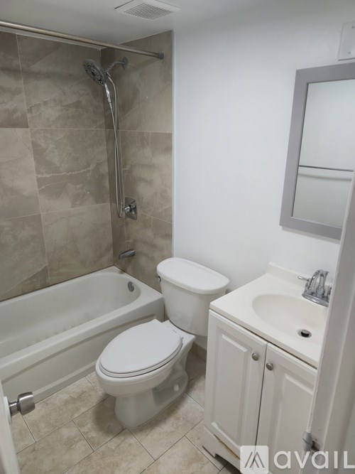 A bathroom with a white toilet, sink, and bathtub.