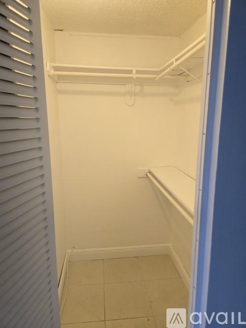 A small, empty room with a white ceiling and a blue wall.