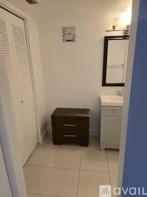 A small bathroom with a toilet, sink, and a wooden stool.