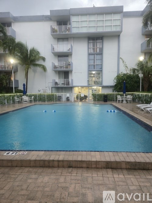 A large swimming pool in front of a building with a sign that says "AVAIL".