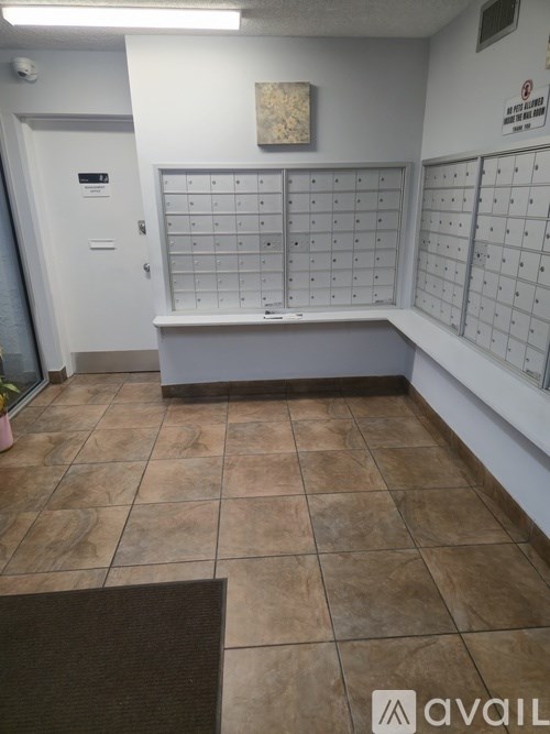 A room with a calendar on the wall and a brown mat on the floor.