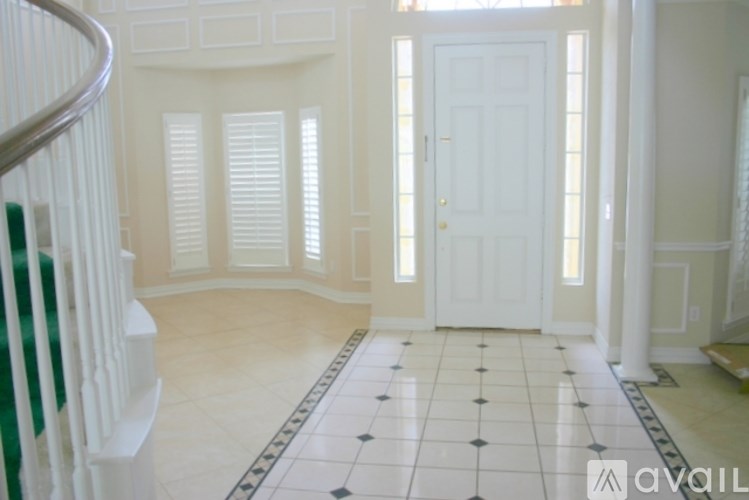 A hallway with a white door and a tiled floor.