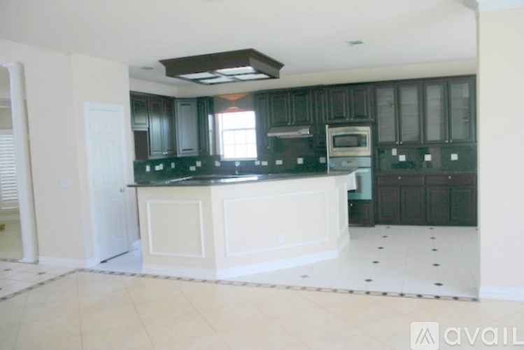 A kitchen with green cabinets and a white island.