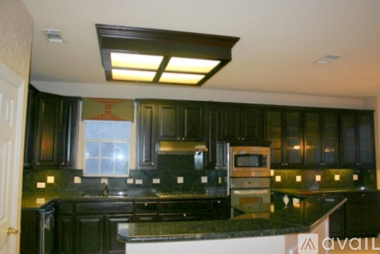 A kitchen with black cabinets and a black counter top.
