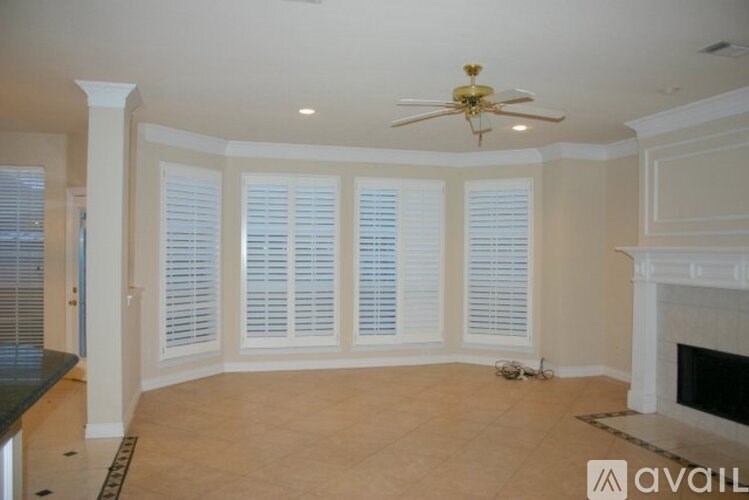 A living room with a fireplace and a fan.