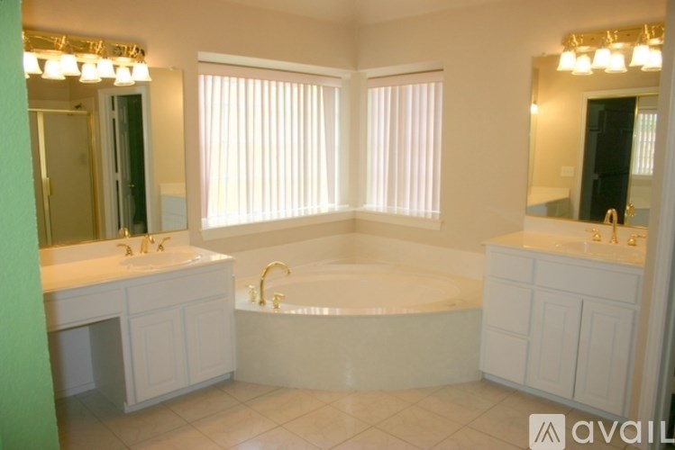 A bathroom with a tub, sink, and mirror.