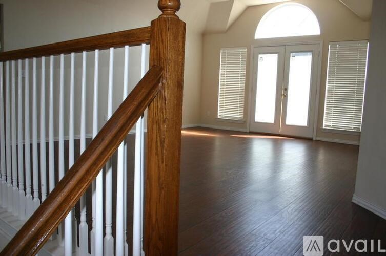 A room with a wooden staircase and a white door.