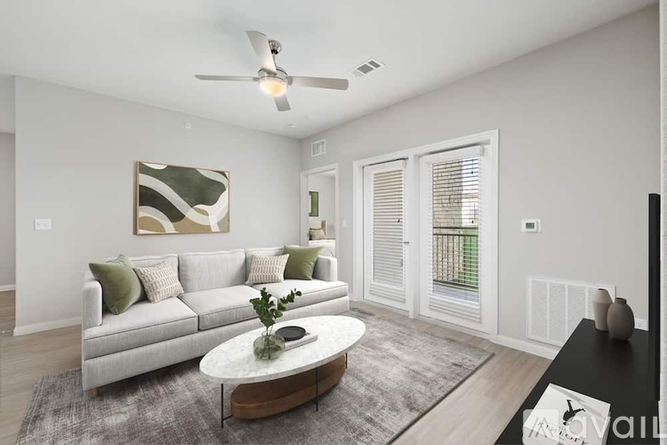 A living room with a grey couch, a coffee table, and a painting on the wall.