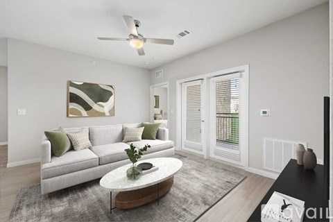 A living room with a grey couch, a coffee table, and a painting on the wall.