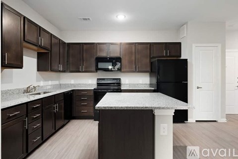 A kitchen with dark brown cabinets and a black refrigerator.