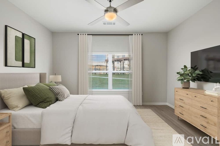 A bedroom with a large bed, a ceiling fan, and a window with blinds.