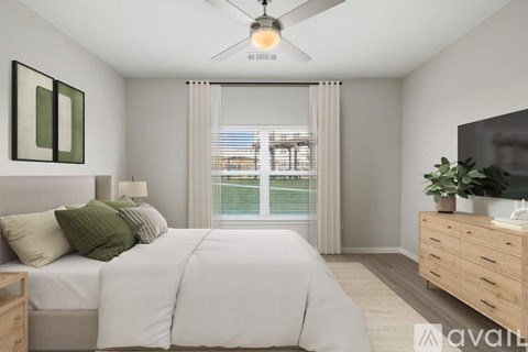 A bedroom with a large bed, a ceiling fan, and a window with blinds.