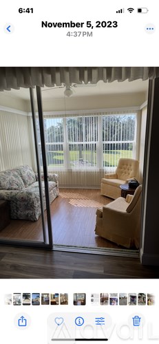 A room with a couch, chair, and a box on the floor.