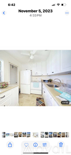 A kitchen with white cabinets and a ceiling fan.