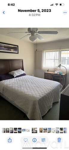 A bed with a white cover is in the foreground of the image.
