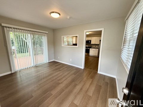 A room with wooden flooring and a sliding glass door.