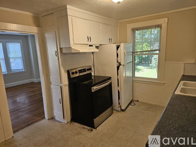 A kitchen with black appliances and white cabinets.