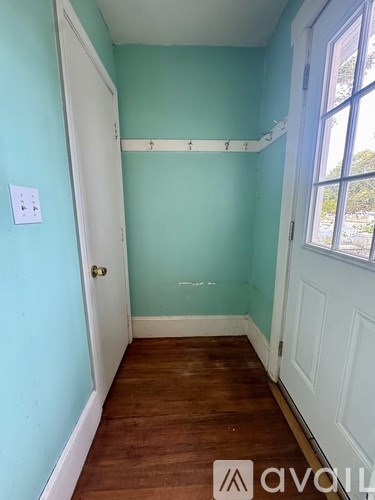 A room with wooden floors and a window with blinds.
