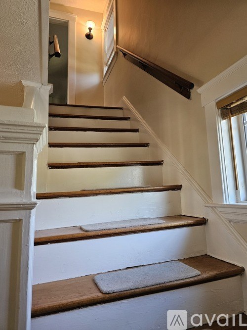 A staircase with wooden steps and a white balustrade.