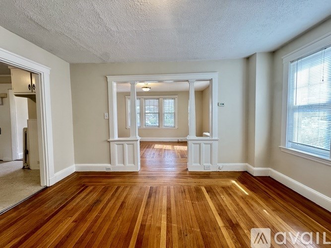 A long hallway with wood floors and white walls.