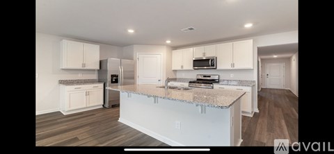 A kitchen with white cabinets and a granite countertop.