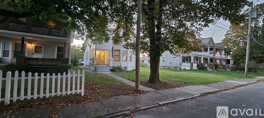A room with wooden flooring and a window with blinds.