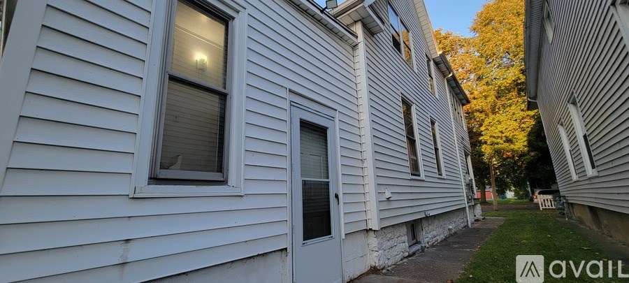 A white house with a tree in front of it.