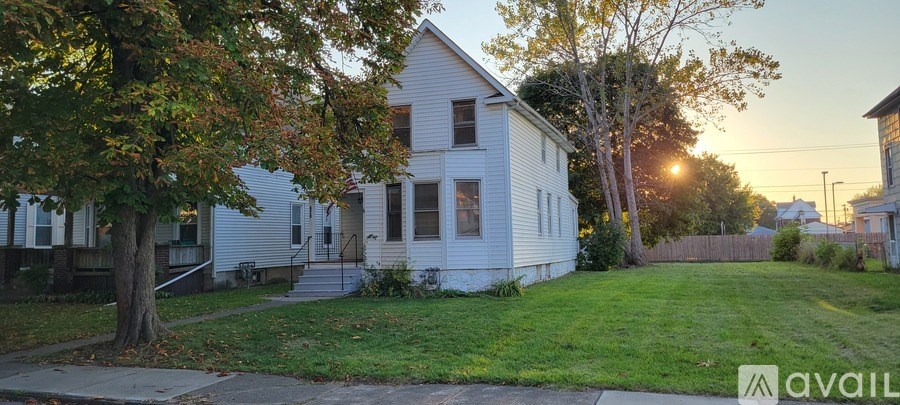 A white house with a tree in front of it.