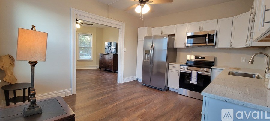 A kitchen with a refrigerator, microwave, and oven.