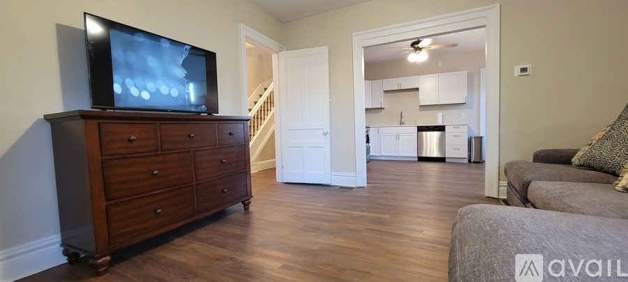 A living room with a television on a dresser and a couch.