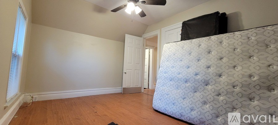 A bedroom with a large bed and a ceiling fan.
