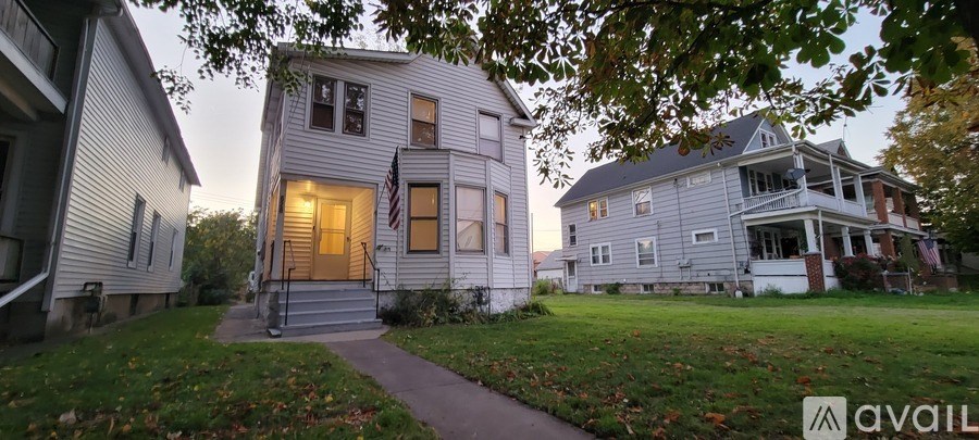 A house with a flag on the front porch is available for sale.