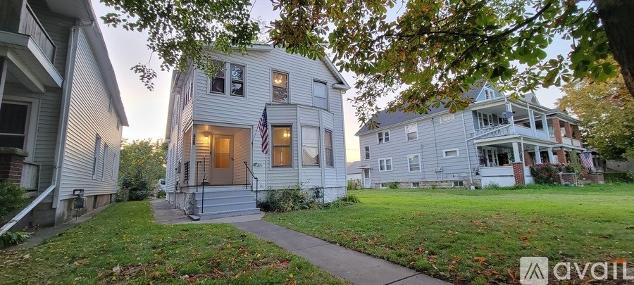 A house with a flag on the front porch is for sale.
