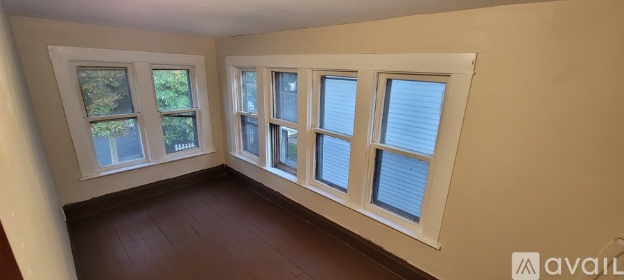 A room with four windows and wooden floors.