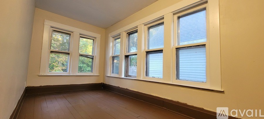 A room with two windows and wooden flooring.