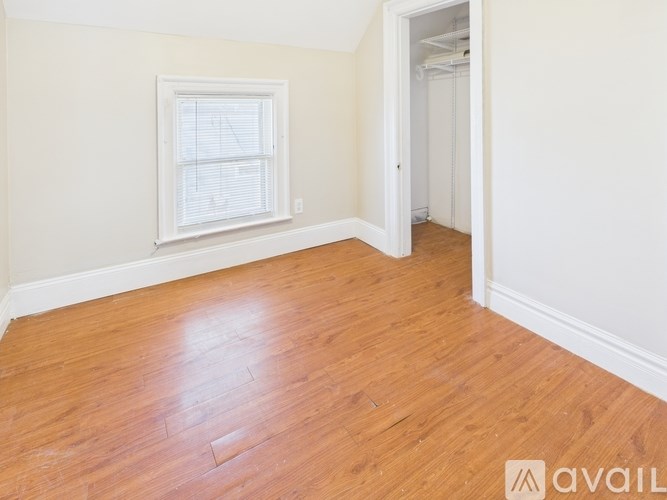 A room with wooden flooring and a window.