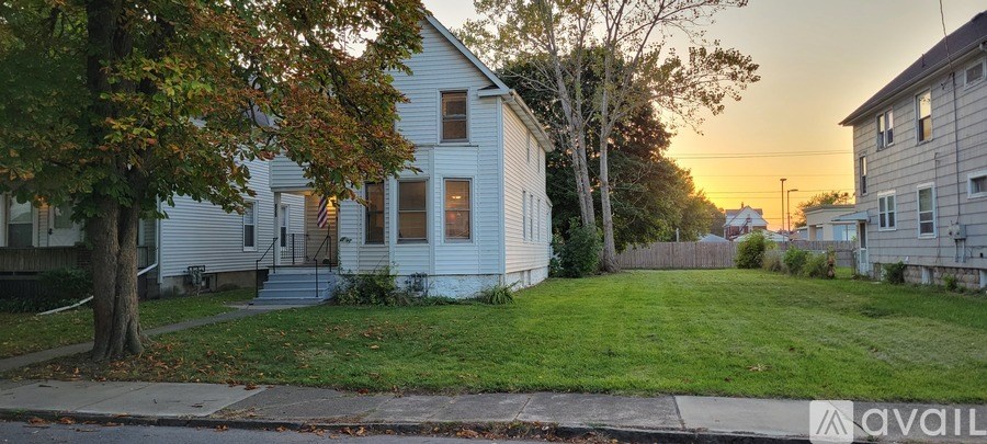 A white house with a tree in front of it.