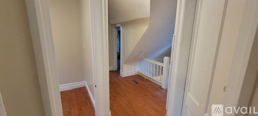 A hallway with a staircase leading to a blue room.